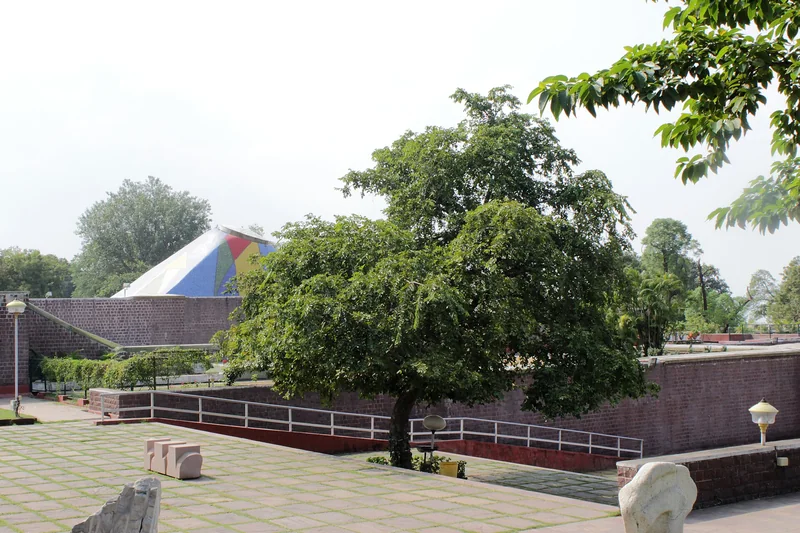 भारत भवन के खुले आँगन, नीचे जाते रास्ते, पेड़ और नीची ईंट की दीवारें